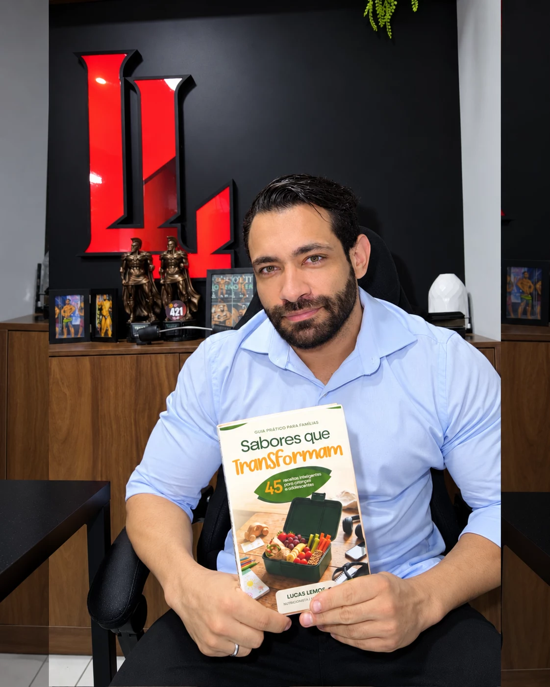 Lucas Lemos, nutricionista, segurando o material Sabores que Transformam